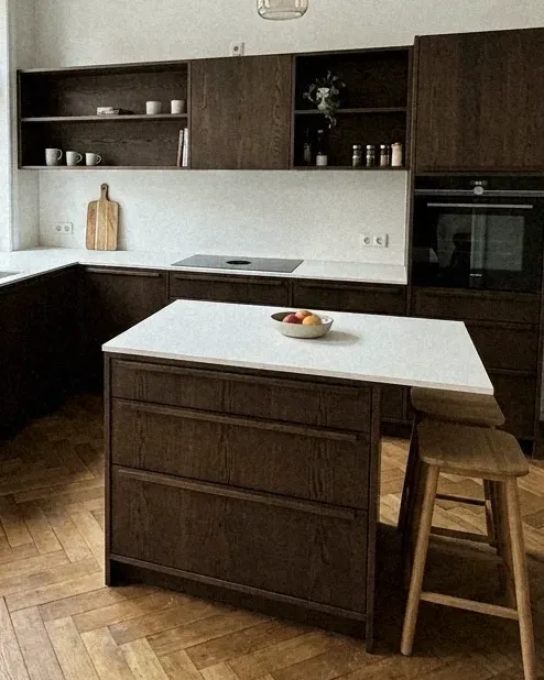 Symbolbild: Kochinsel und Küchenfronten aus dunkler Eiche, daneben Backofen und Hochschrank